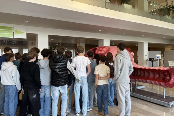 Schüler betrachten ein großes Modell eines menschlichen Organs im Inneren eines Gebäudes.
